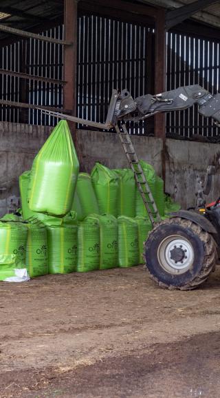 forklift moving cable feed in green bags