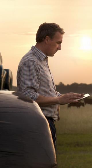Farmer working in the field looking at his ipad